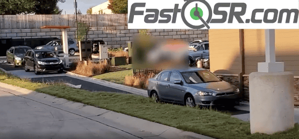 A drive-thru with a long line of cars.