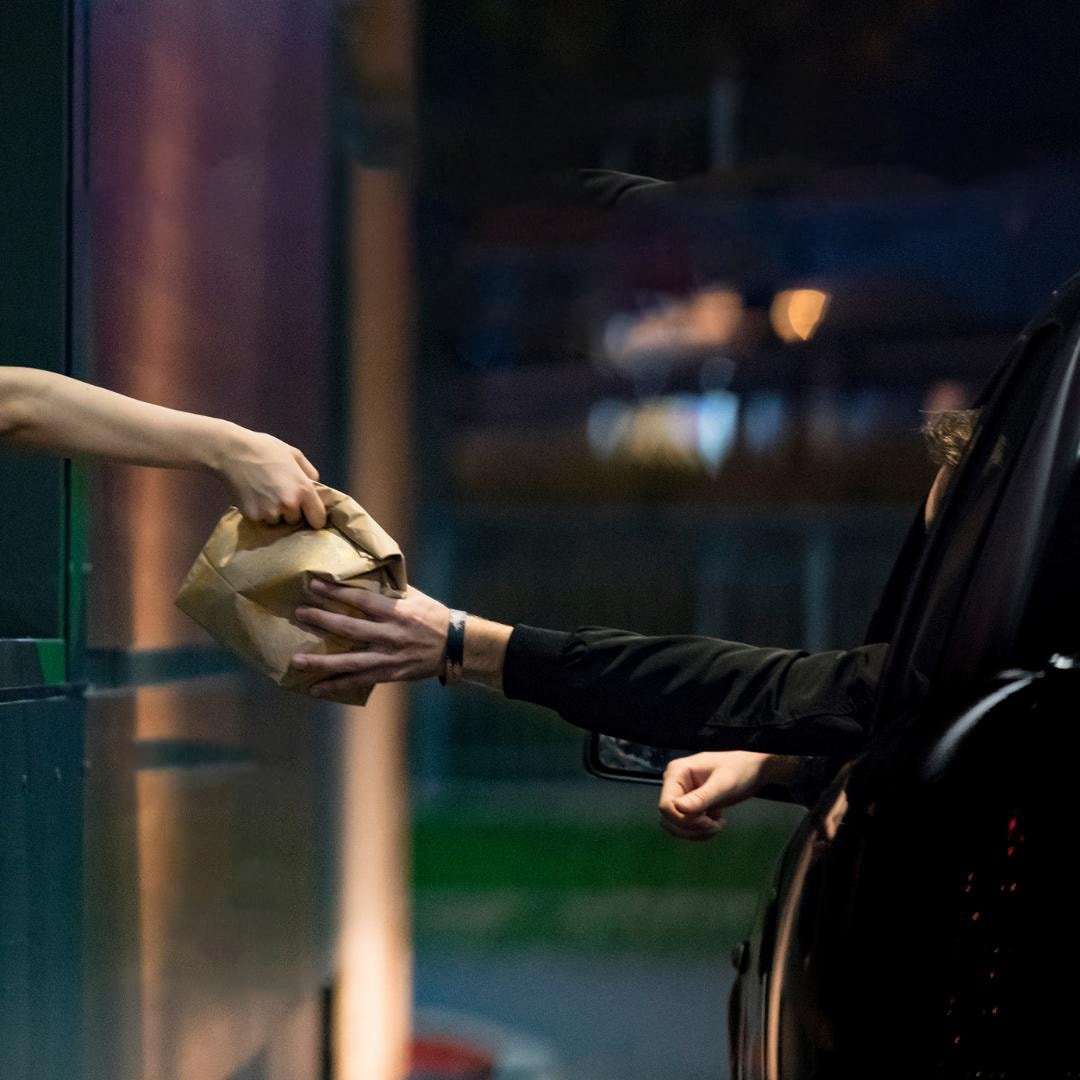 Person grabbing a bag from drive thru.